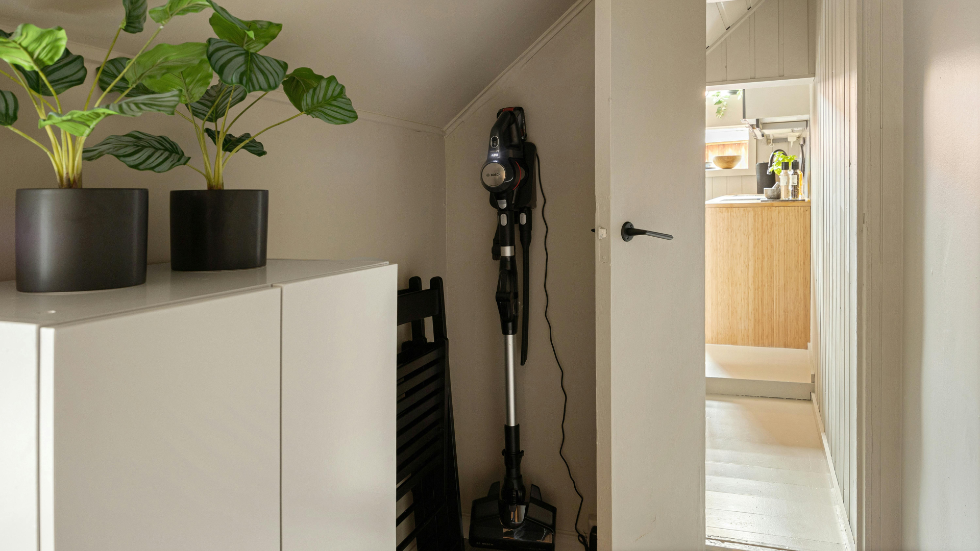 Odkurzacz pionowy na stacji dokującej w nowoczesnym wnętrzu