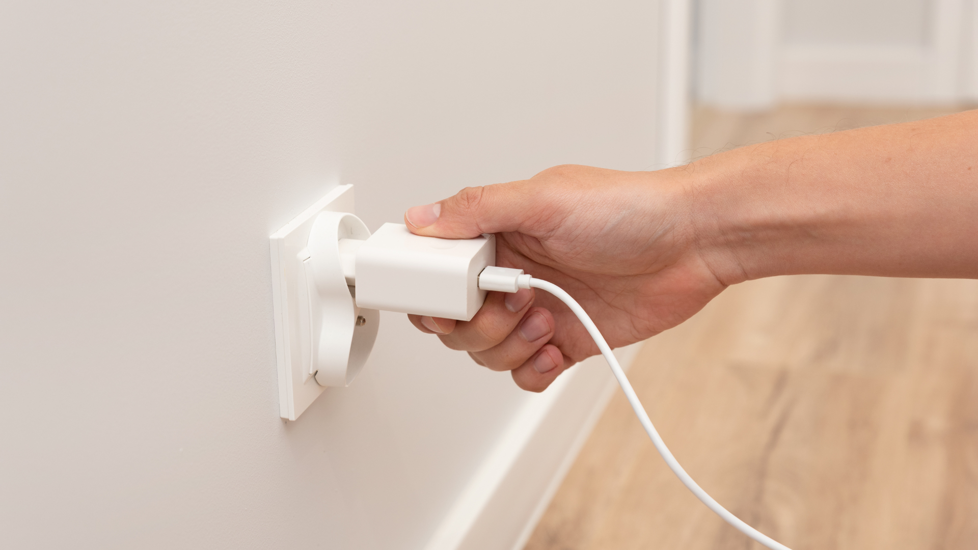 Ładowarka GaN 65W w gniazdku, dłoń dla skali