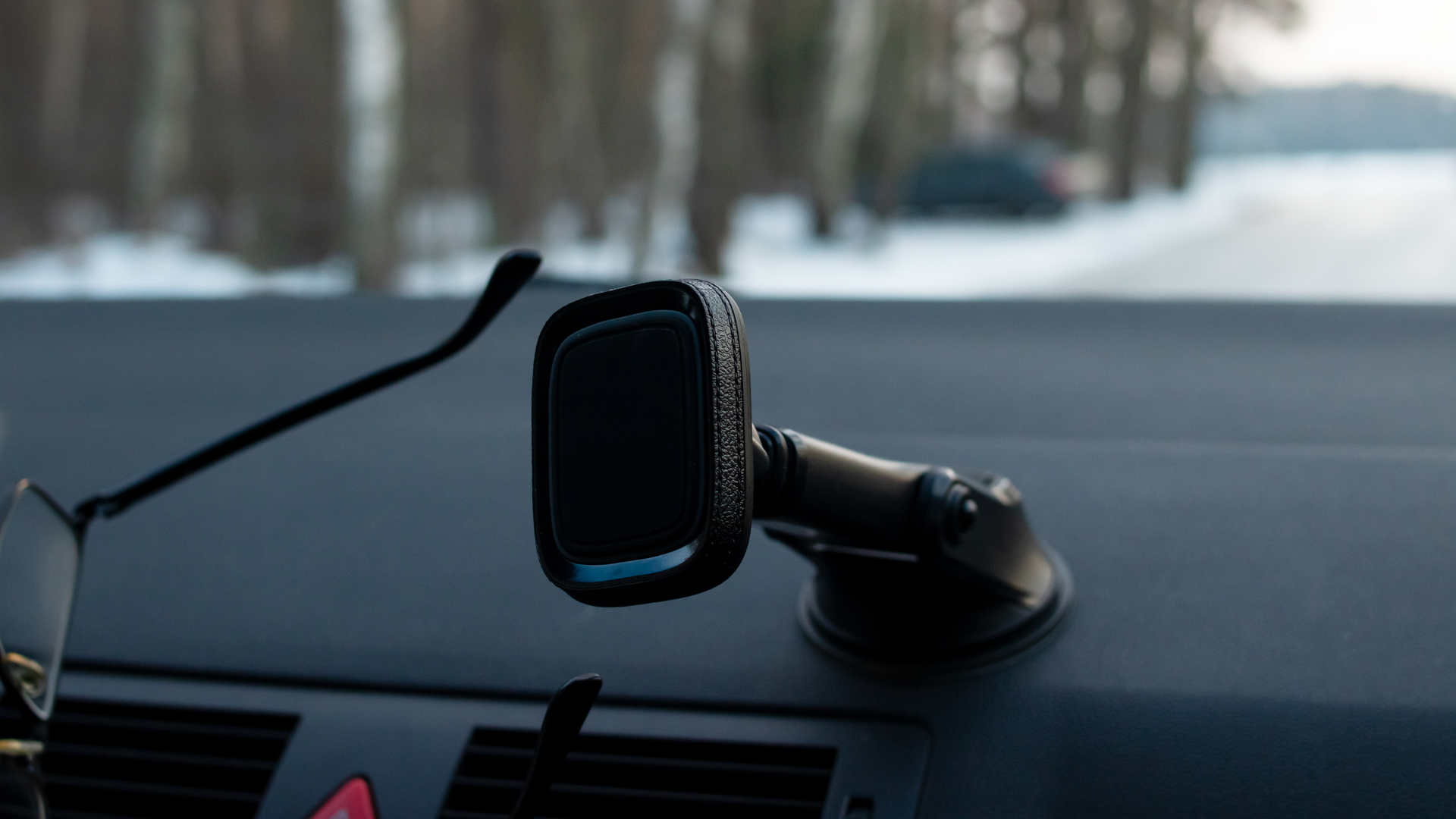 Uchwyt na szybę z długim ramieniem – perspektywa kierowcy, miasto w tle