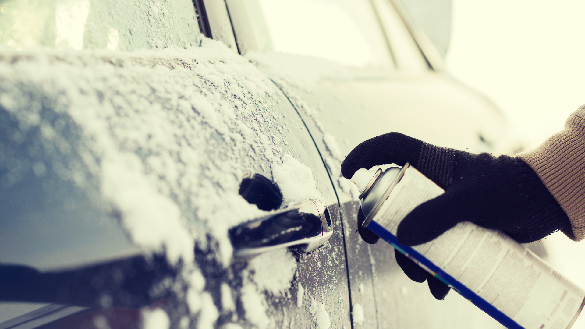 Zestaw zimowy: skrobaczka, rękawice, odmrażacz w bagażniku na tle śniegu