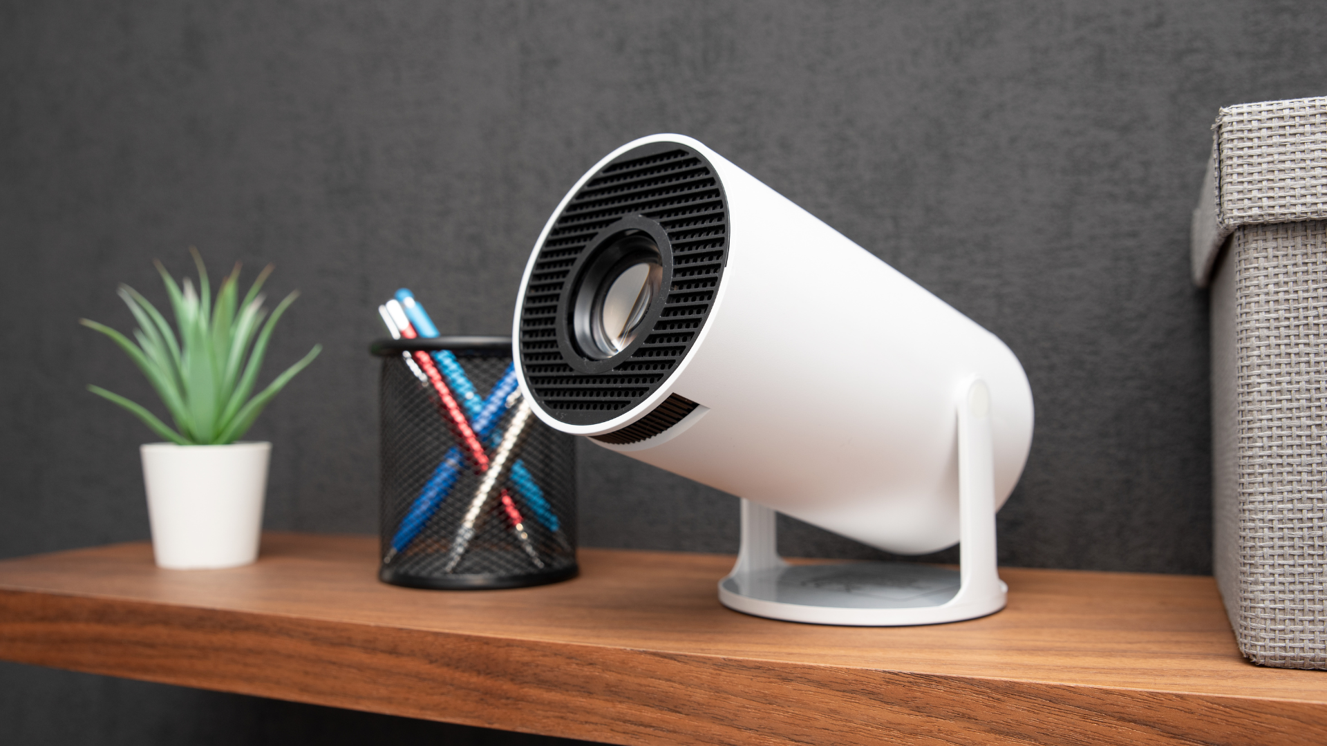 Projektor na półce i rozwijany ekran w salonie – wieczorna, ciepła atmosfera